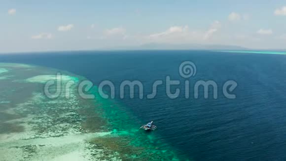 在蓝色水域的珊瑚礁上的船巴拉巴克巴拉望菲律宾视频的预览图