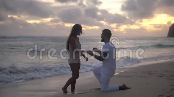 一对幸福的情侣在海边男友单膝跪下求婚视频的预览图