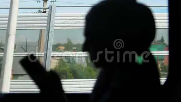 穆斯林妇女在火车途中看电话的剪影视频的预览图
