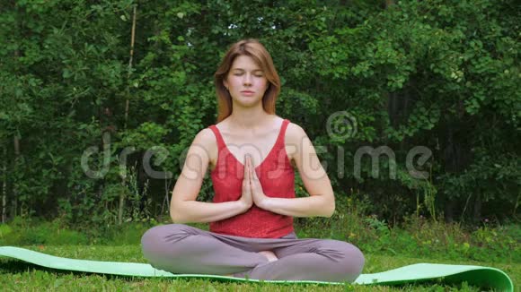 年轻漂亮的女孩在大自然中练习瑜伽视频的预览图