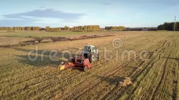 关闭拖拉机驱动打包机推动草捆在田间视频的预览图