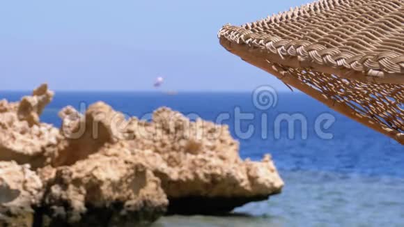 太阳伞在一个珊瑚海滩上埃及的岩石和石头在红海上视频的预览图