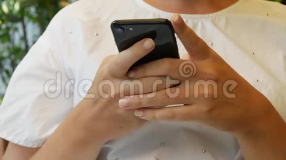 女孩用智能手机写信息聊天年轻的女人在电话里寻找信息坐在里面视频的预览图