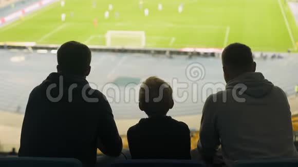 男支持者和孩子在体育场观看足球比赛讨论比赛视频的预览图
