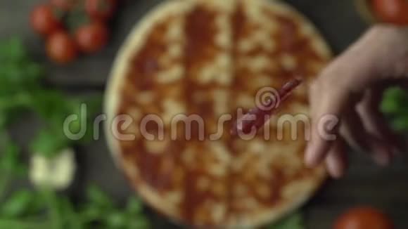 厨师把意大利辣味香肠扔到比萨饼上视频的预览图