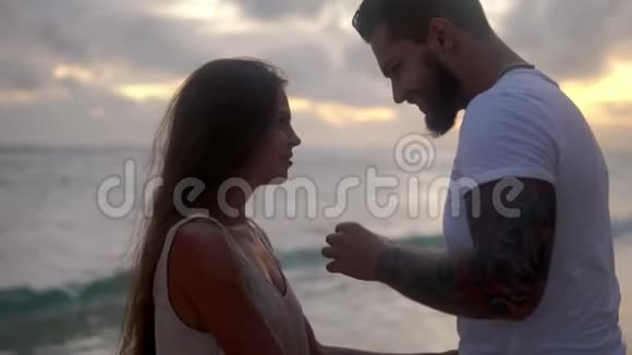 一对幸福的情侣在海边沙滩上男人跪下求婚视频的预览图