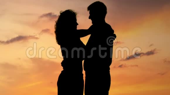 快乐的情侣在日落时拥抱和亲吻恋爱故事视频的预览图