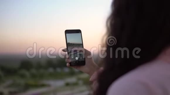 一个女孩正在用智能手机拍摄一个城市的照片慢动作视频的预览图