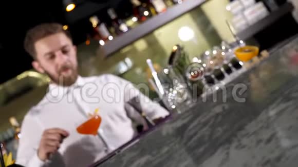 酒保把杯子和新鲜的鸡尾酒视频的预览图
