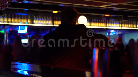 一个人在酒吧柜台跳舞喝酒看俱乐部里的人视频的预览图