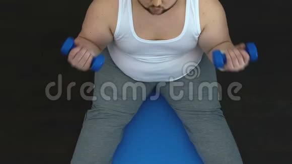 运动肥胖男子举起哑铃和显示成功的手势后锻炼视频的预览图