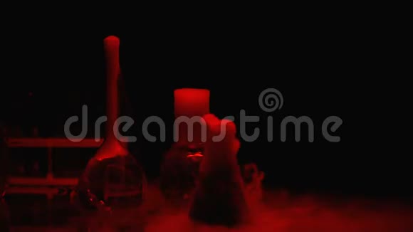 烧瓶中的化学物质在红灯下冒泡和散发烟雾实验室视频的预览图