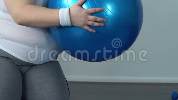精疲力竭的胖子带着健身球摔倒在地板上缺乏运动能量视频的预览图