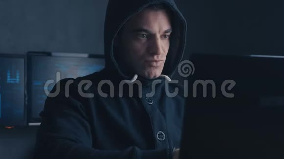 网络犯罪概念一个被通缉的黑客在黑暗的办公室里用电脑视频的预览图