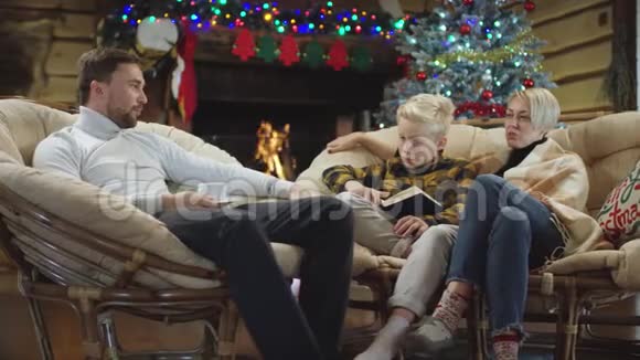 男人在圣诞夜和一个小男孩和一个女人谈论一本书视频的预览图
