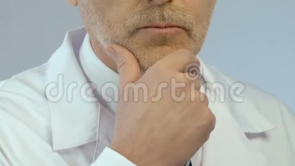 解决问题的中年医生用手在下巴上做决定视频的预览图
