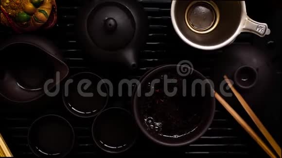 茶几上的中国茶冲泡仪式带有变焦的黑色背景视频的预览图
