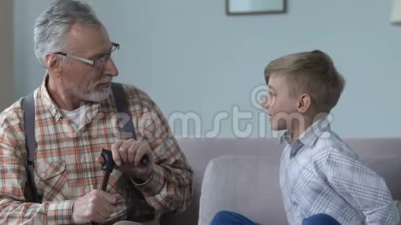 可爱的男孩送礼物盒祖父幸福的家庭时刻爱情关系视频的预览图