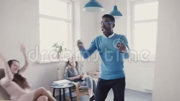 快乐的非裔美国商人庆祝促销与有趣的舞蹈步行成功的老板在现代办公室4K视频的预览图
