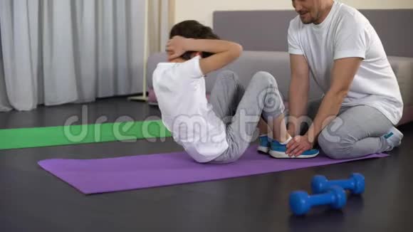 小孩做仰卧起坐给他父亲打高五在家锻炼视频的预览图