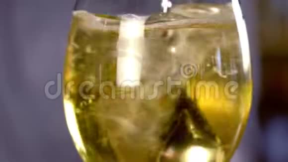 酒保将酒精鸡尾酒与起泡酒混合冰和酒用调羹盛在酒杯里特写镜头视频的预览图