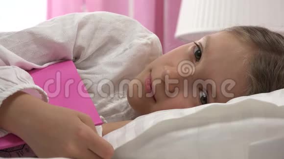 睡在床上的悲伤体贴的孩子不睡觉睡在卧室里醒来的女孩的脸视频的预览图