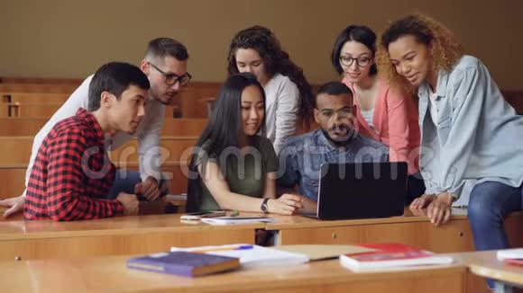 一群学生正在使用笔记本电脑坐在教室里聊天年轻人在项目上工作现代视频的预览图