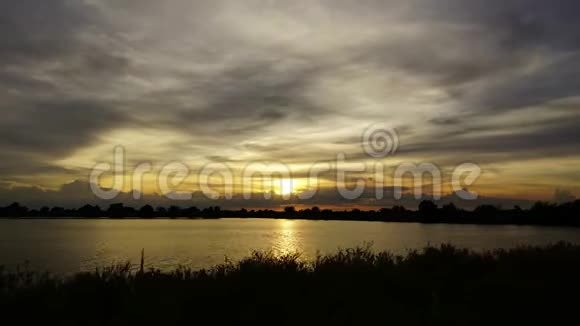时间流逝日落后移动的云在沼泽上方发出美丽的金光视频的预览图