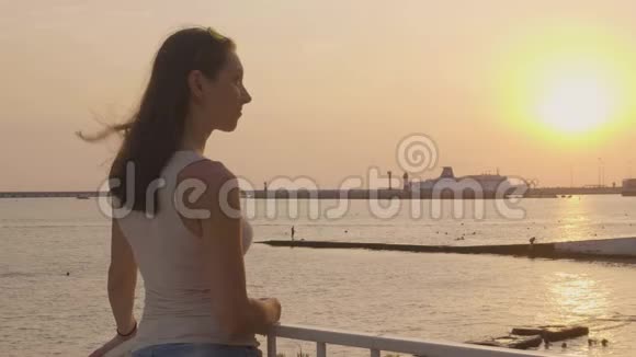年轻的女人在海上看傍晚的日落夜空景观视频的预览图