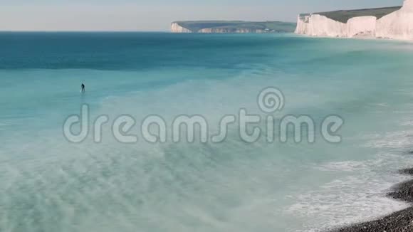 一个在冲浪板上划着桨去岩石海岸的人视频的预览图