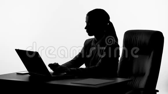 女老板在她的笔记本电脑上工作接电话内部信息视频的预览图