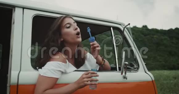 戴着牙套的女孩吹着蓝色的泡泡4k视频的预览图