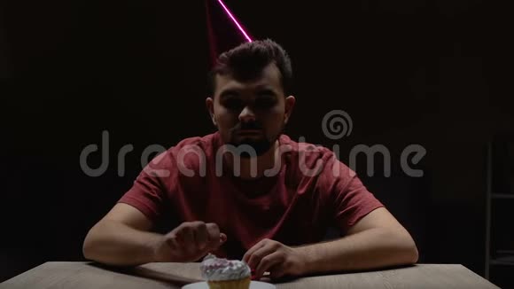 孤独的单身汉在家里在生日蛋糕上点蜡烛缺少朋友视频的预览图