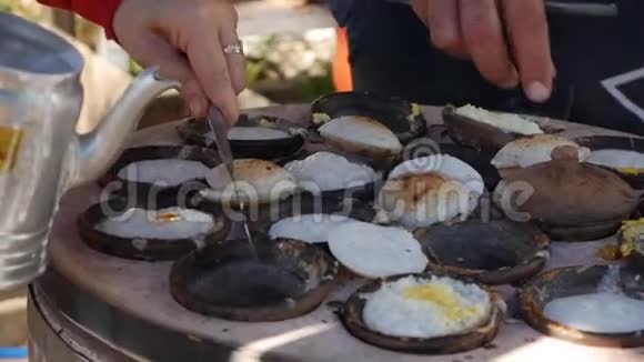 越南街头美食供应商准备的面包罐是一种带有鸡蛋的米饼越南著名的菜肴蛋糕的加工过程从视频的预览图
