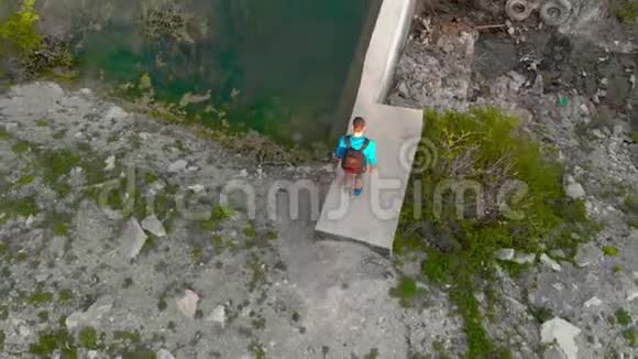沿着一个小水坝在山上徒步旅行跟踪视频的预览图