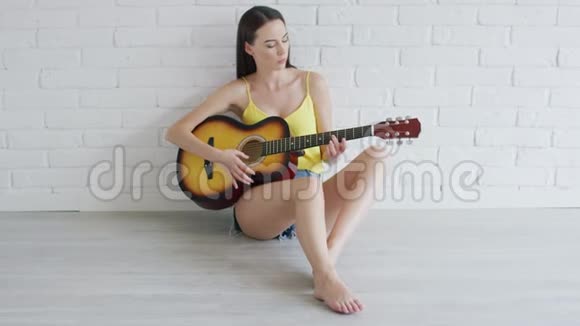 带着吉他看镜头的年轻女子视频的预览图