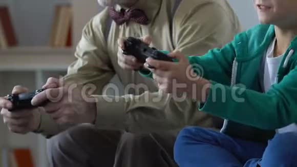 兴奋的男孩与祖父在电子游戏中竞争家庭亲密视频的预览图