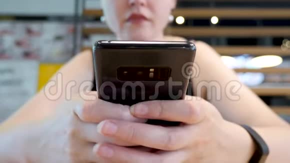 关闭无法辨认的女人检查她的智能手机视频的预览图