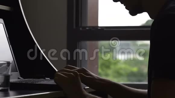 快乐的男人在网上和朋友聊天在笔记本电脑上输入信息玩得开心视频的预览图