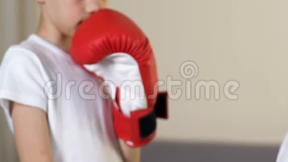 父亲帮儿子戴拳击手套在家训练体育教育视频的预览图