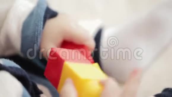 快乐的小宝宝玩五颜六色的乐高立方体孩子的发展一个一岁的小男孩在玩视频的预览图