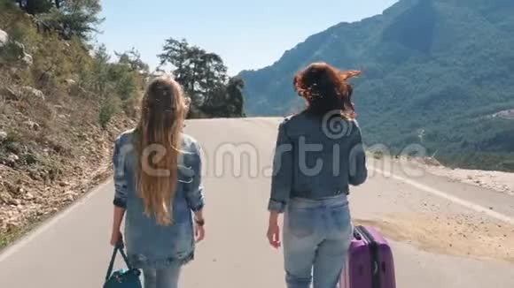 两个年轻女孩走在路上带着美丽的自然景观视频的预览图