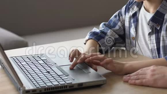 儿子在笔记本电脑上给父亲看作业用现代技术进行教育视频的预览图