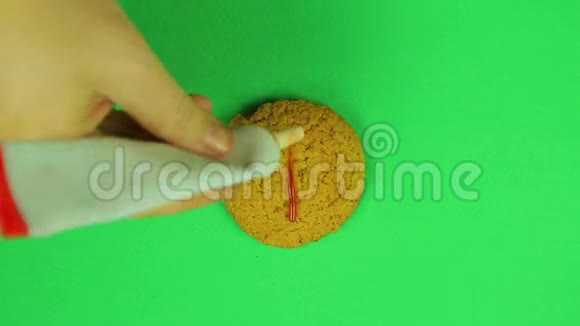 孩子在卢布招牌饼干上画了一块绿色背景的棕色糖霜时间跨度视频的预览图
