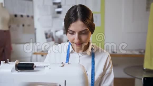 年轻的女裁缝在缝纫工作室里做缝纫机视频的预览图