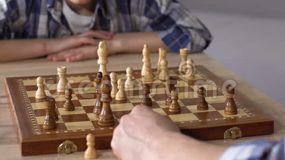父亲在家和小儿子下棋大脑发育活动特写视频的预览图