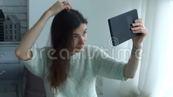 女人用平板电脑调头像镜子视频的预览图