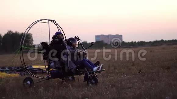 摩托车滑翔伞在机场和一个女孩和一个男人一起起飞加速降落到空中视频的预览图