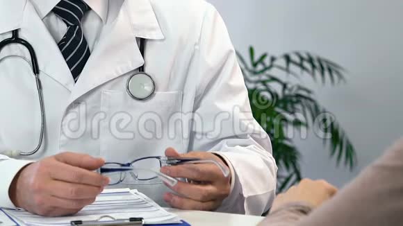 密切男性眼科医生为病人选择眼镜检查视频的预览图