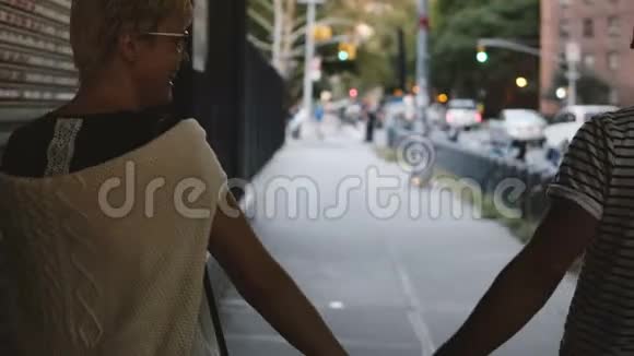 快乐轻松的成年浪漫情侣一起牵着手微笑着走在纽约城的傍晚视频的预览图